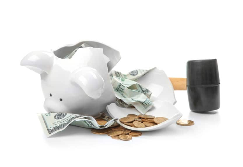 Broken piggy bank with money and hammer on white background