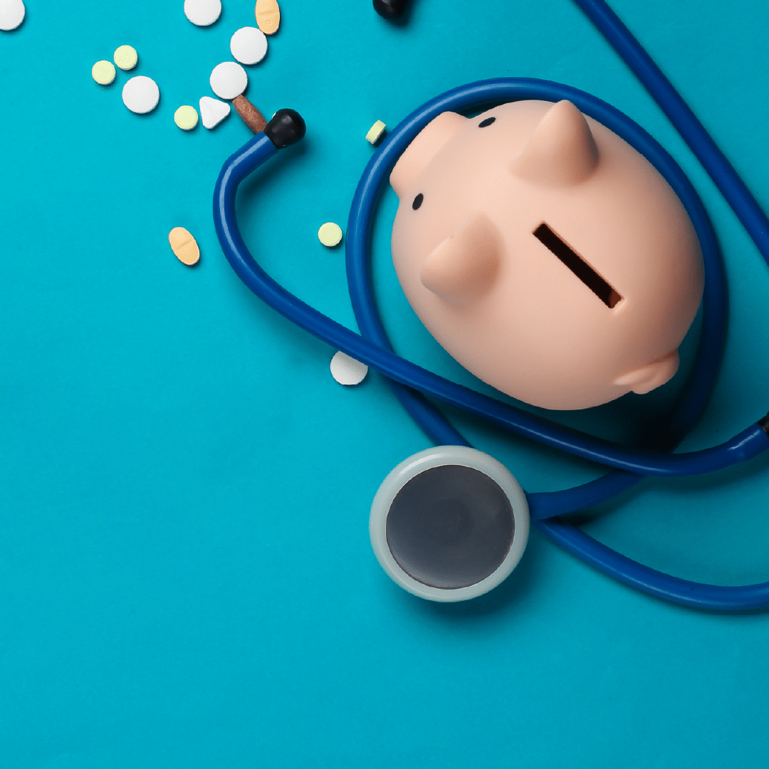 An image of pills, a stethoscope, and a piggy bank