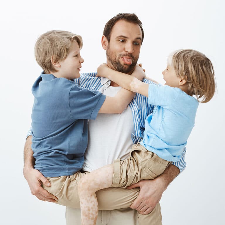 Adult man carrying two children