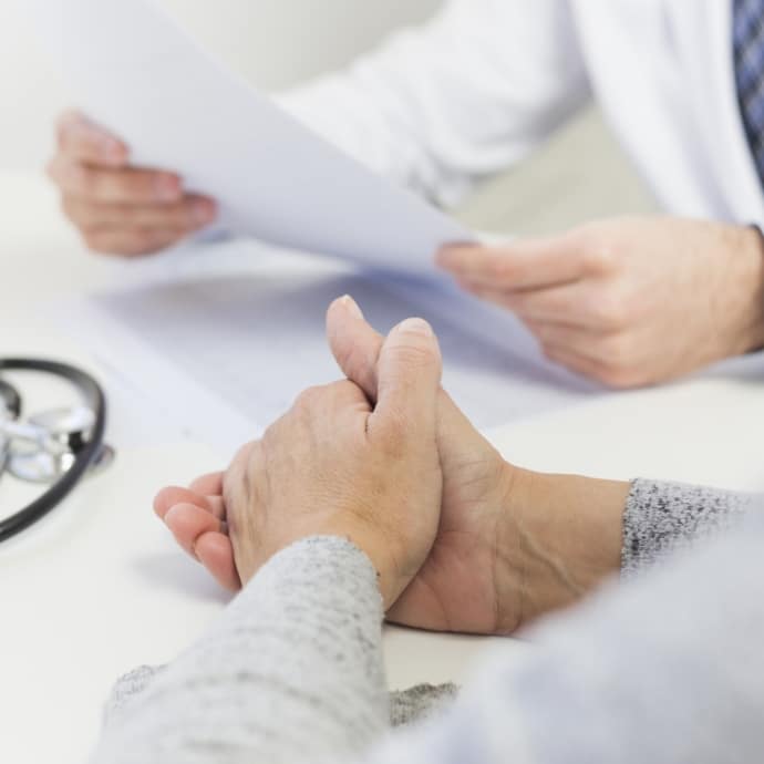 close up female patient sitting near doctor holding medical report